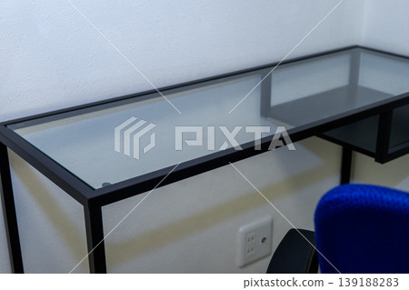 A modern space featuring empty glass tables and blue chairs. 139188283