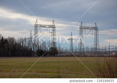 Electrical substation with high voltage power lines and pylons under cloudy sky Electrical substation with high voltage power lines and pylons under cloudy sky 139189035