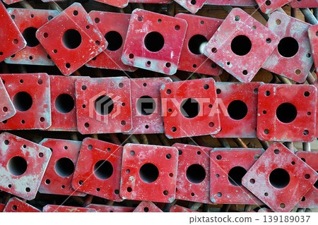 Stacked red steel construction beam end plates with bolt holes Stacked red steel construction beam end plates with bolt holes 139189037