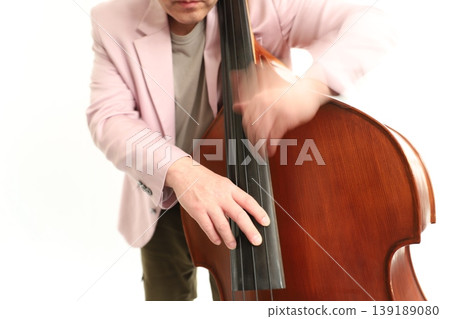 一名男子用手指演奏低音提琴(倍低音提琴),充滿活力。 一名男子用手指演奏低音提琴(倍低音提琴),充滿活力。 139189080