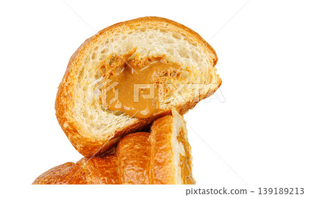 Half of croissant with caramel cream filling isolated on white. Professional studio food macro shot. Half of croissant with caramel cream filling isolated on white. Professional studio food macro shot. 139189213