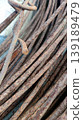 Shows a close-up of several rusty iron rebars stacked together. The textured, oxidized surface displays varying shades of brown and orange, highlighting the effects of weathering on metal. 139189479