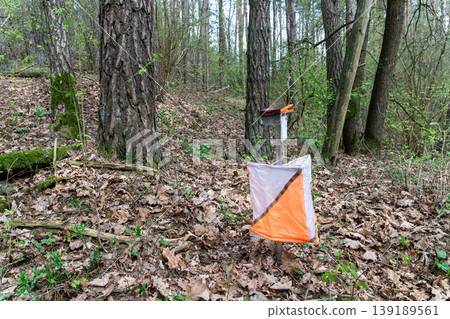 Orienteering control point with orange and white flag Orienteering control point with orange and white flag 139189561