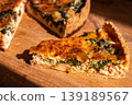 Traditional Lorraine quiche made from shortcrust pastry with an egg-and-cream filling and red fish, close-up of a slice of quiche on a wooden oak board, delicious homemade pastries 139189567