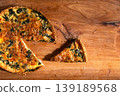 Top view of a traditional Lorraine quiche with red fish in an egg-and-cream filling lying on a wooden board, traditional delicious French pastries 139189568