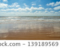 poster inviting you to a vacation on secluded Mediterranean beaches, a resort overlooking a magnificent sea view from a sandy beach, the blue sky reflected on the wet sand, copy space for text 139189569