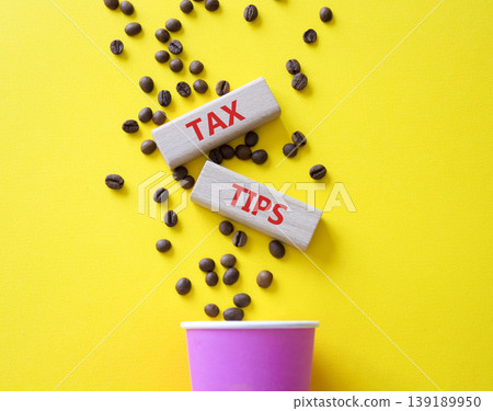 Tax Tips symbol. Wooden blocks with words Tax Tips. Beautiful yellow background with coffee cup and coffee beans. Business and Tax Tips concept. Copy space. Tax Tips symbol. Wooden blocks with words Tax Tips. Beautiful yellow background with coffee cup and coffee beans. Business and Tax Tips concept. Copy space. 139189950