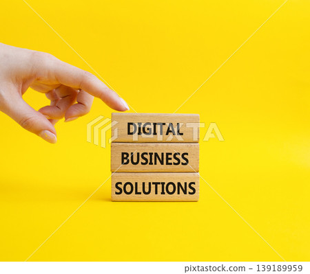Digital Business Solutions symbol. Concept word Digital Business Solutions on wooden blocks. Businessman hand. Beautiful yellow background. Business and Digital Business Solutions. Copy space 139189959