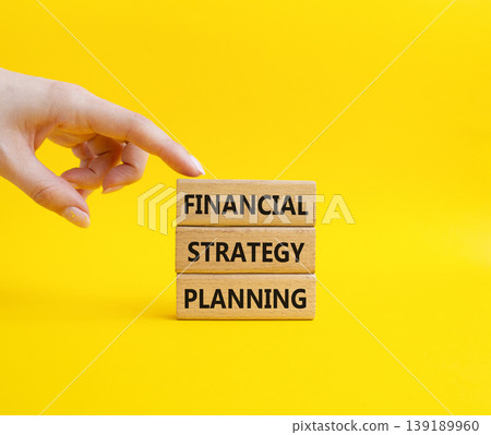 Financial strategy planning symbol. Concept word Financial strategy planning on wooden blocks. Businessman hand. Beautiful yellow background. Business and Financial strategy planning. Copy space Financial strategy planning symbol. Concept word Financial strategy planning on wooden blocks. Businessman hand. Beautiful yellow background. Business and Financial strategy planning. Copy space 139189960