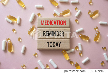 MEDICATION REMINDER TODAY symbol. Concept words MEDICATION REMINDER TODAY on wooden blocks. Beautiful pink background with pills. Healthcare and MEDICATION REMINDER TODAY concept. Copy space. MEDICATION REMINDER TODAY symbol. Concept words MEDICATION REMINDER TODAY on wooden blocks. Beautiful pink background with pills. Healthcare and MEDICATION REMINDER TODAY concept. Copy space. 139189969