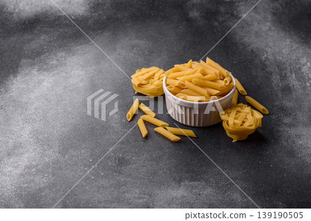 Italian uncooked dry penne regate pasta ready for cooking. Dry penne pasta 139190505