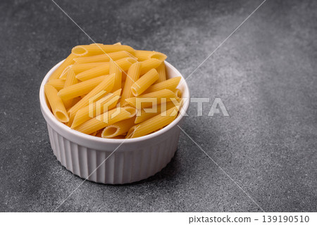 Italian uncooked dry penne regate pasta ready for cooking. Dry penne pasta Italian uncooked dry penne regate pasta ready for cooking. Dry penne pasta 139190510