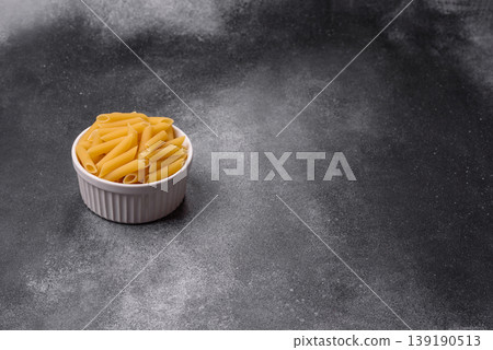Italian uncooked dry penne regate pasta ready for cooking. Dry penne pasta Italian uncooked dry penne regate pasta ready for cooking. Dry penne pasta 139190513