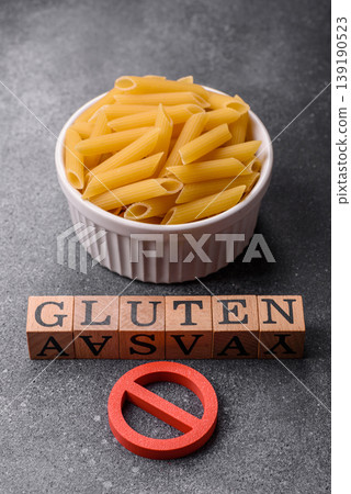 Italian uncooked dry penne regatta pasta with a gluten prohibition sign. The gluten prohibition sign 139190523