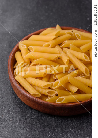 Italian uncooked dry penne regate pasta ready for cooking. Dry penne pasta Italian uncooked dry penne regate pasta ready for cooking. Dry penne pasta 139190531