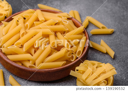 Italian uncooked dry penne regate pasta ready for cooking. Dry penne pasta Italian uncooked dry penne regate pasta ready for cooking. Dry penne pasta 139190532