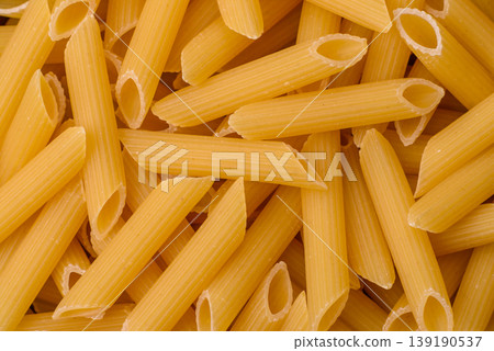 Italian uncooked dry penne regate pasta ready for cooking. Dry penne pasta 139190537