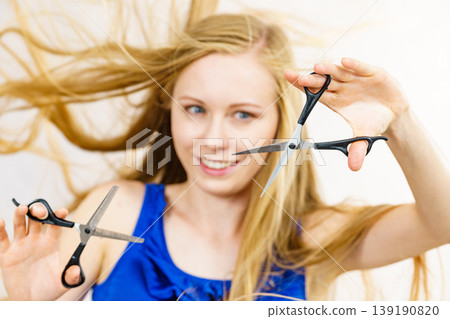 Young woman with scissors for haircutting Young woman with scissors for haircutting 139190820