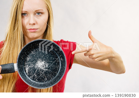 Girl holding scratched frying pan 139190830