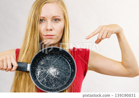 Girl holding scratched frying pan 139190831