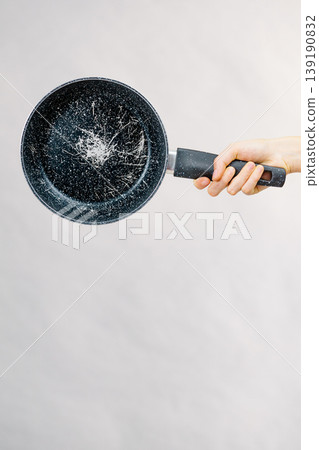 Hand holding scratched frying pan Hand holding scratched frying pan 139190832