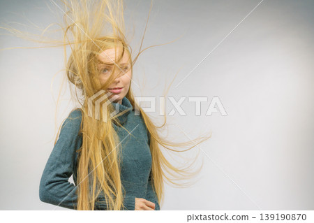 Girl with hair flying around her face Girl with hair flying around her face 139190870