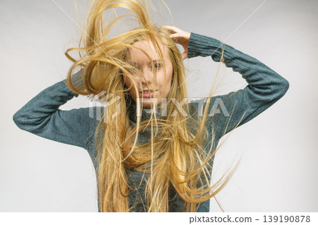 Girl with hair flying around her face Girl with hair flying around her face 139190878