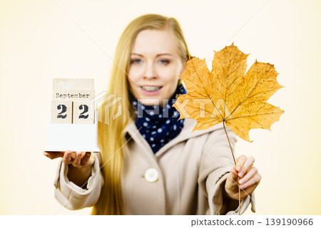 Woman holding calendar with first autumn day 139190966
