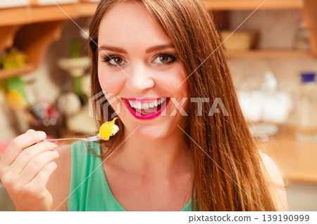 Woman eating cream cake with fruits. Gluttony. 139190999