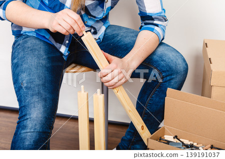 Woman assembling wood furniture. DIY. 139191037
