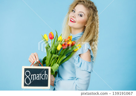 Woman holds tulips, board with text 8 march Woman holds tulips, board with text 8 march 139191067