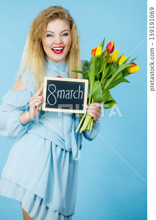 Woman holds tulips, board with text 8 march Woman holds tulips, board with text 8 march 139191069