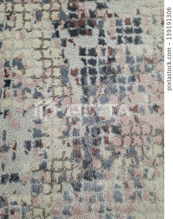 The view shows a plush carpet with an abstract pixelated pattern made of cream, pink, and navy blue colors. The rug is placed on a flat surface, highlighting its design and texture. 139191306