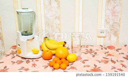 bunch of bananas and citrus fruits next to a blender on the table bunch of bananas and citrus fruits next to a blender on the table 139191540