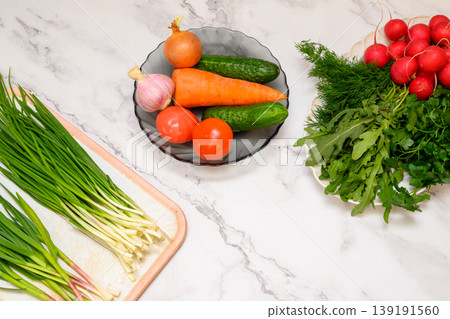 assorted fresh vegetables greens and a bunch of green onions on marble assorted fresh vegetables greens and a bunch of green onions on marble 139191560