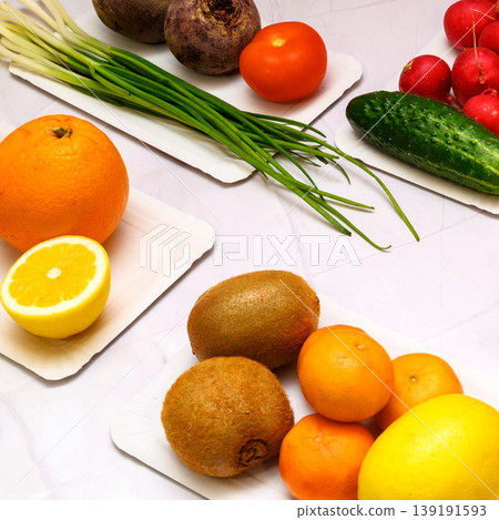 assortment of vegetables and fruits on white plates including kiwi radish and cucumber 139191593