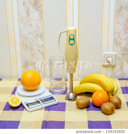 immersion blender with scales and fruits on a checkered tablecloth immersion blender with scales and fruits on a checkered tablecloth 139191605