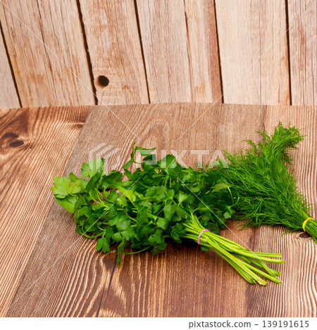 two bunches of fresh green parsley and dill on a wooden table 139191615