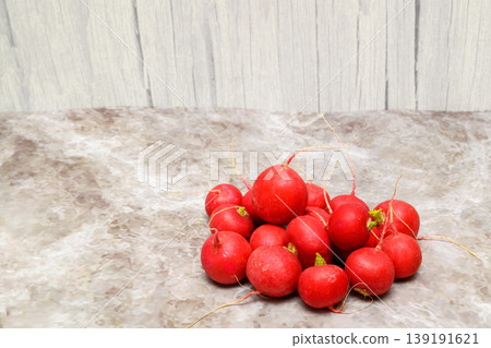 ripe red radishes on a marble background near a wooden wall ripe red radishes on a marble background near a wooden wall 139191621