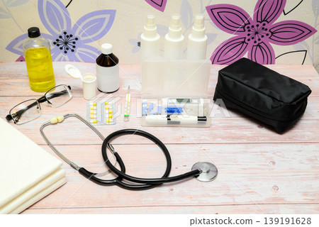 medical stethoscope and sugar measurement kit on a light table by a wall with flowers medical stethoscope and sugar measurement kit on a light table by a wall with flowers 139191628