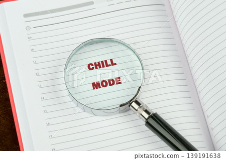 A magnifying glass rests on an open daily planner. The phrase Chill Mode appears magnified in red text on the lined page, indicating a focus on relaxation 139191638