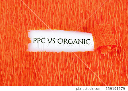 Conceptual presentation of PPC versus Organic marketing strategies on a white background, breaking through vibrant orange textured paper Conceptual presentation of PPC versus Organic marketing strategies on a white background, breaking through vibrant orange textured paper 139191679