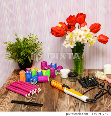 hairdresser workspace with bright flowers, a houseplant and a set of hair curling tools hairdresser workspace with bright flowers, a houseplant and a set of hair curling tools 139191737
