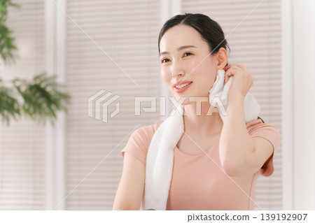 A woman sweating with a towel A woman sweating with a towel 139192907