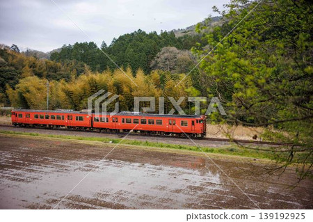 A JR Yamaguchi Line Kiha 47 series diesel railcar runs alongside rice paddies that have just been filled with water. A JR Yamaguchi Line Kiha 47 series diesel railcar runs alongside rice paddies that have just been filled with water. 139192925
