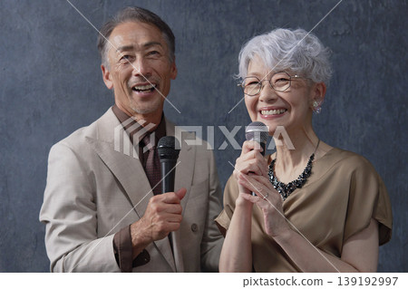 Senior men and women singing karaoke on a black background Senior men and women singing karaoke on a black background 139192997