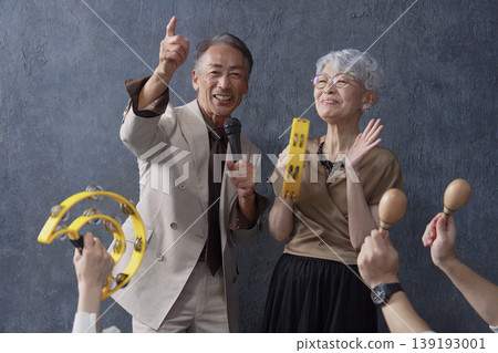 Senior men and women singing karaoke on a black background Senior men and women singing karaoke on a black background 139193001