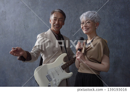Senior musicians: male guitarist and female vocalist, black background 139193016