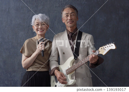 Senior musicians, male guitarist and female vocalist, black background, looking at camera Senior musicians, male guitarist and female vocalist, black background, looking at camera 139193017