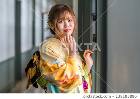 A 20-year-old woman in a furisode kimono stands by the window of a retro, antique Western-style mansion/studio. A 20-year-old woman in a furisode kimono stands by the window of a retro, antique Western-style mansion/studio. 139193890